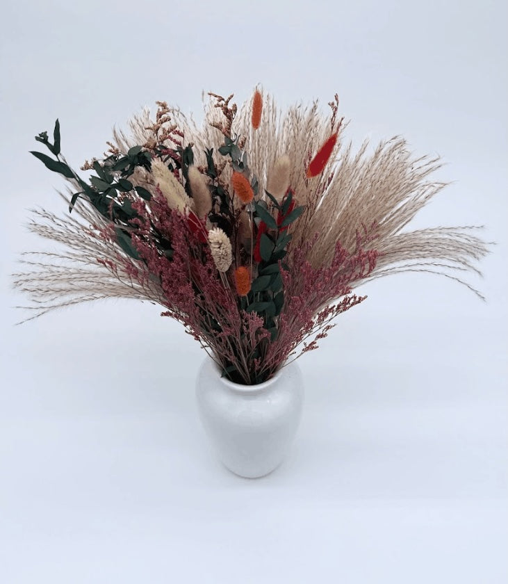 Bouquet of dried flowers and leaves tied with burlap on a white background