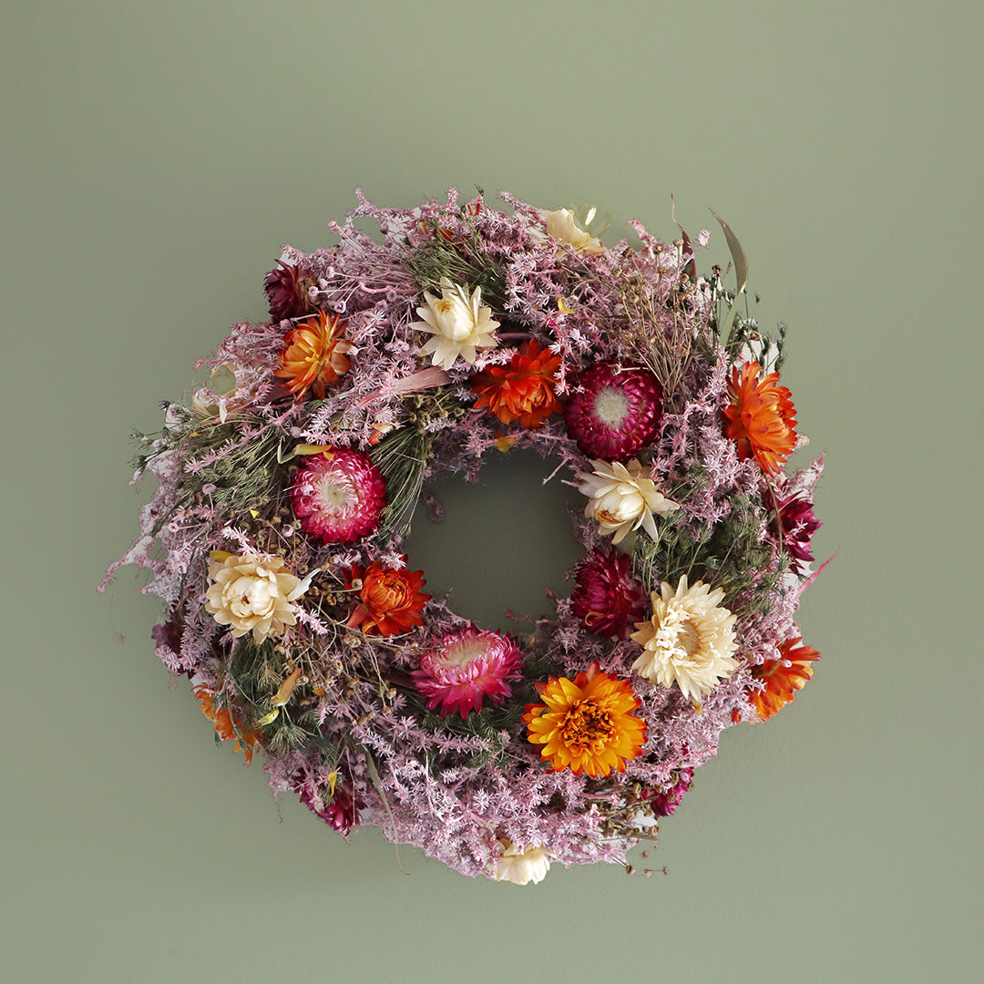 Floral wreath with colorful flowers on a green background