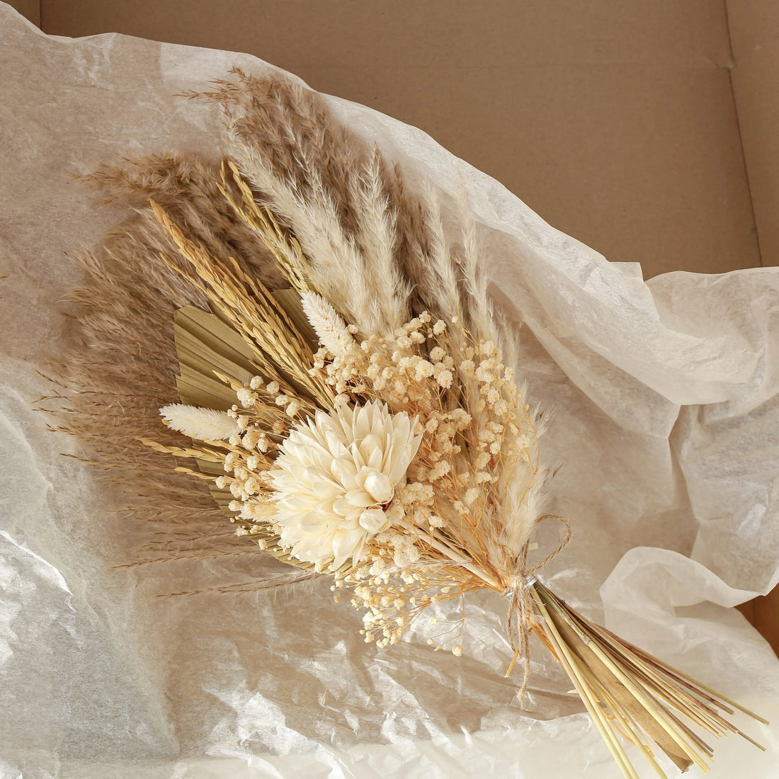 Bouquet of dried flowers and grasses on a soft fabric background