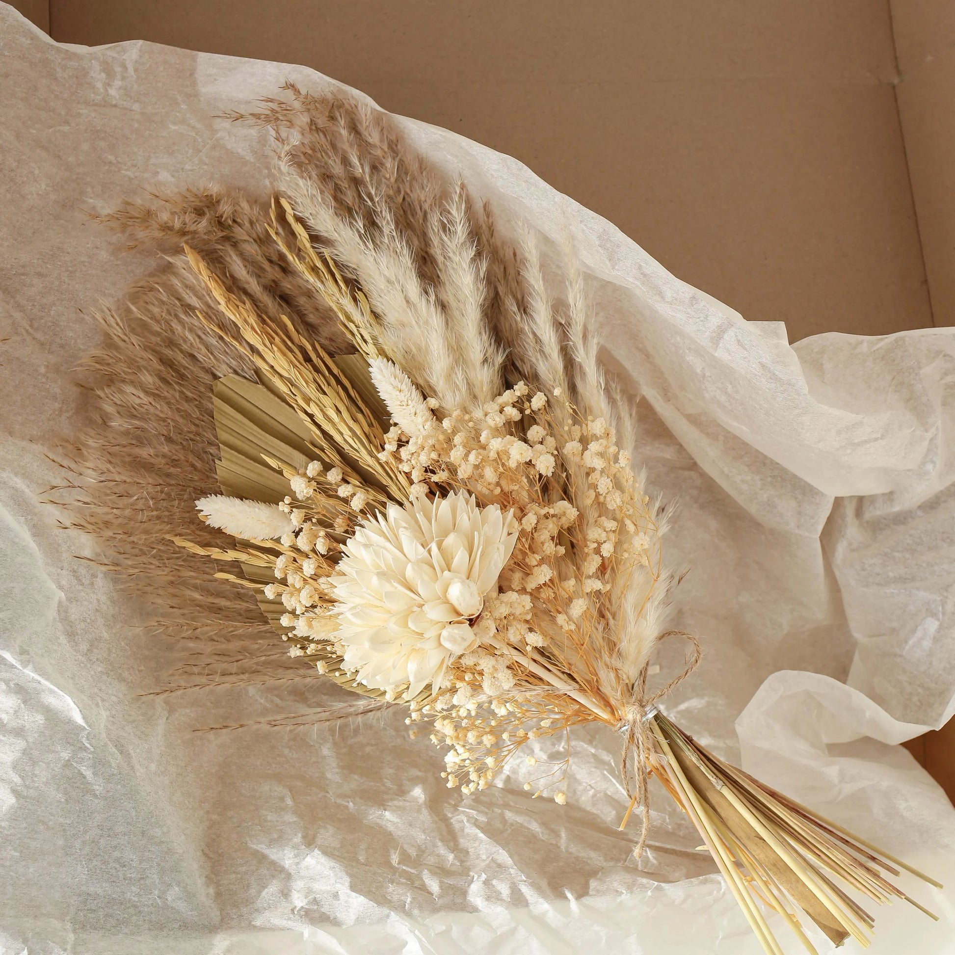 Bouquet of dried flowers and grasses on a soft fabric background