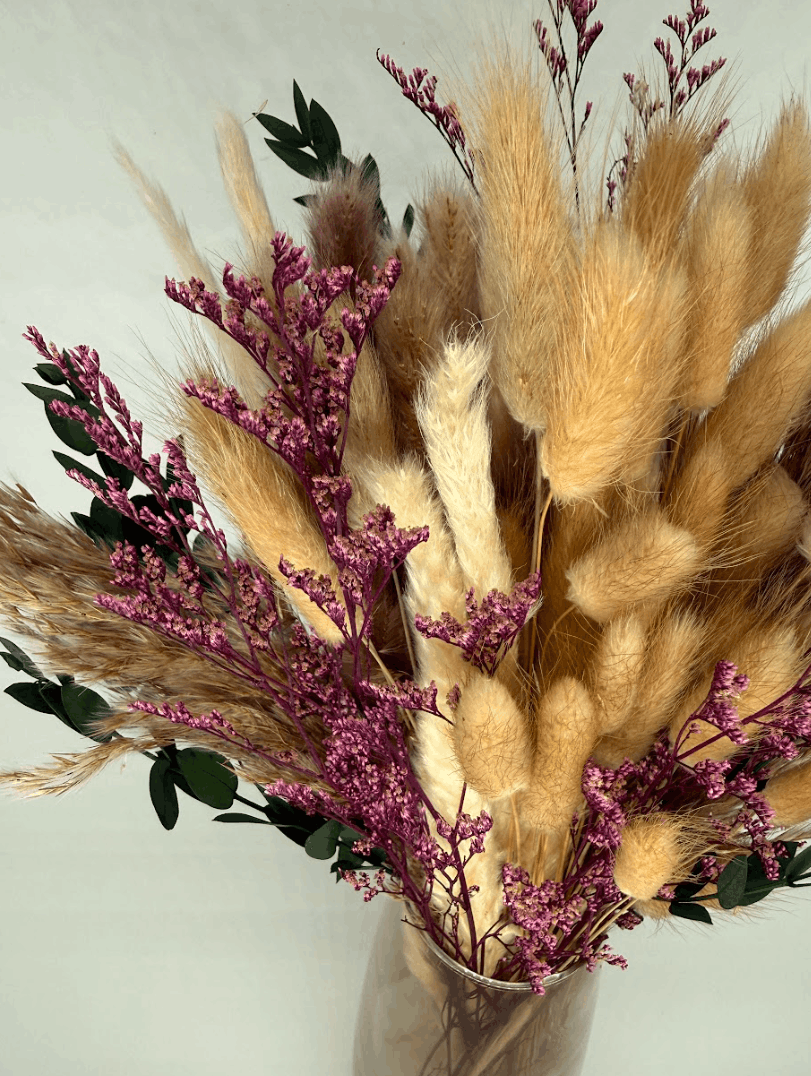 Close-up of boho dried flower arrangement with pampas grass, pink dried flowers, and eucalyptus leaves