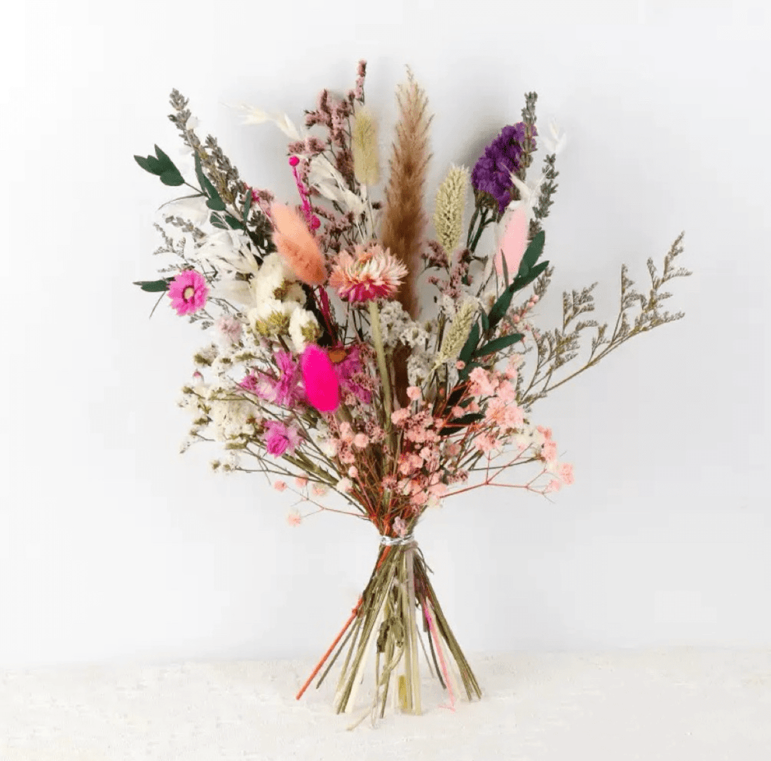 Bouquet of dried flowers with pink, purple, and green colors on a white background