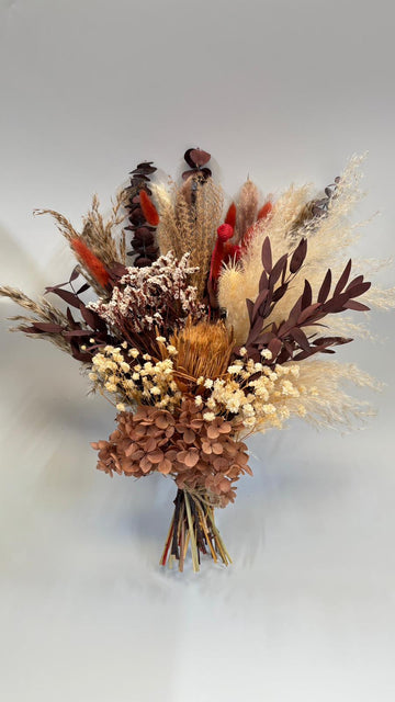 Bouquet of dried flowers and herbs on a light gray background