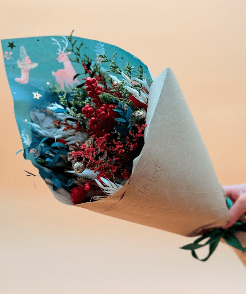 Red and Green Festive Bouquet Wrapped in Christmas paper and brown paper
