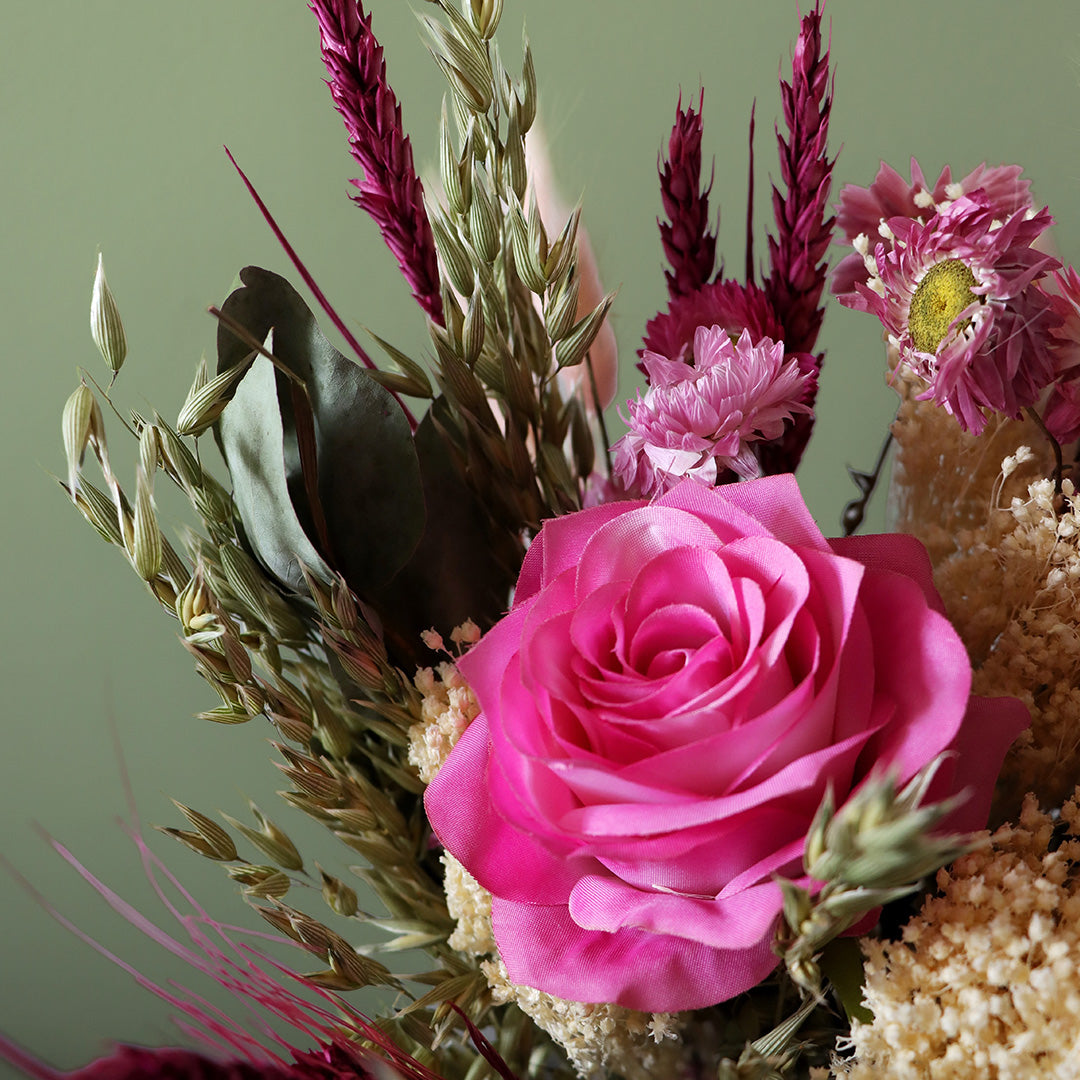 Bouquet of pink roses and other flowers against a green background
