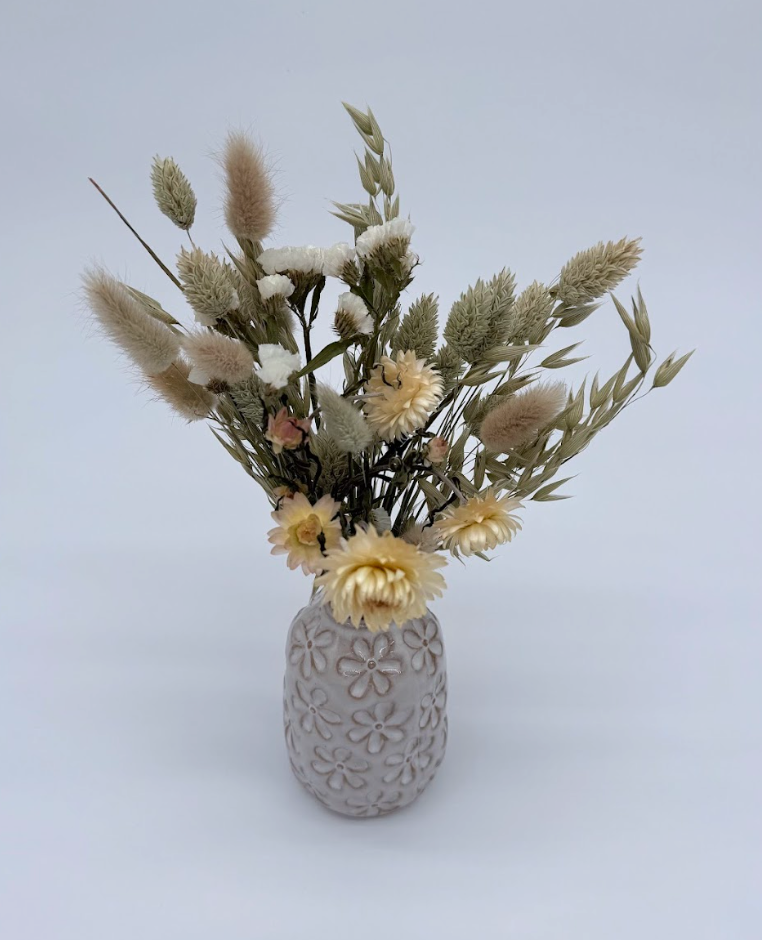 Decorative vase with dried flowers on a light gray background