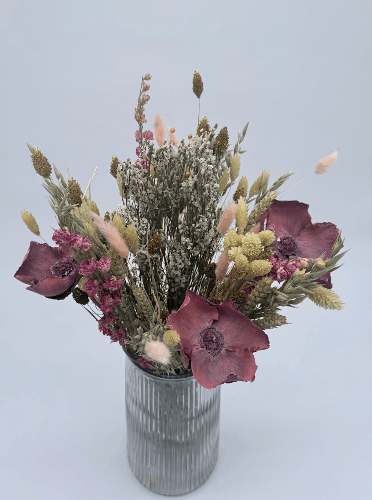 Dried Flower Bouquet with pink flowers and mixed stems in a ribbed glass vase