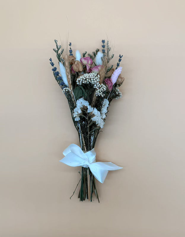 Bouquet of flowers with a white ribbon on a beige background