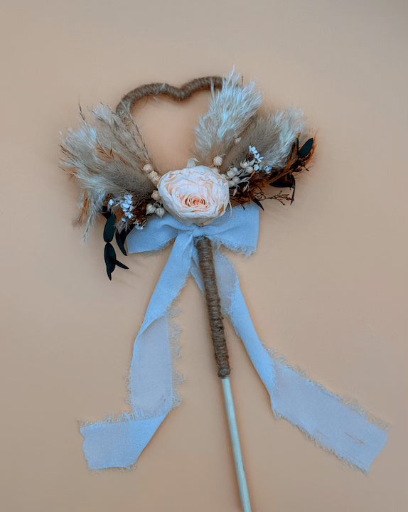 Decorative headband with flowers and feathers on a beige background