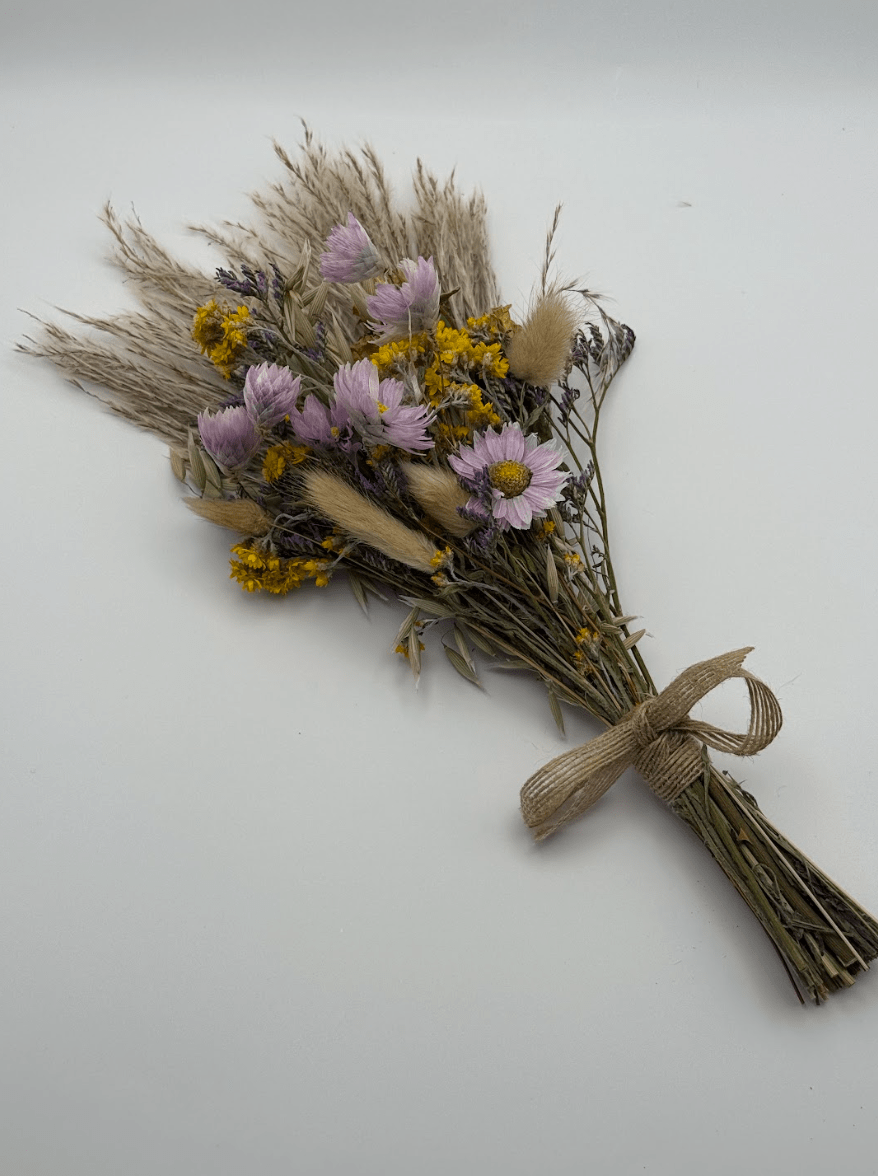 Bouquet of dried flowers tied with twine on a white background