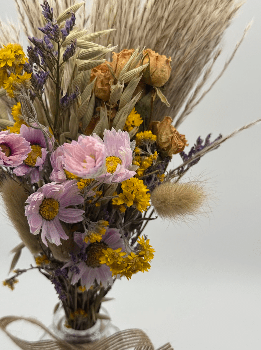 Bouquet of dried flowers with pink, yellow, and purple colors on a light background