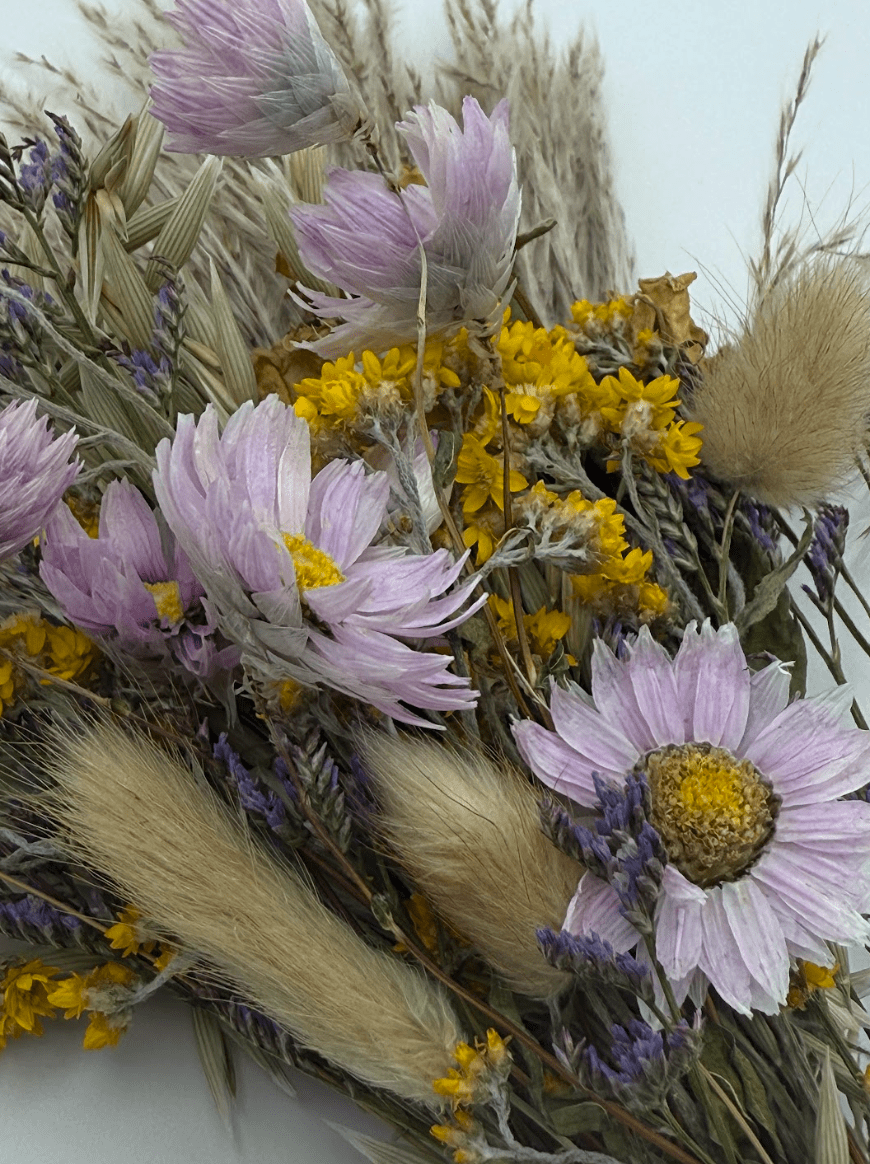 Bouquet of dried flowers with lavender, yellow, and beige tones.