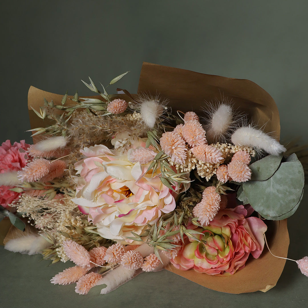 Bouquet of flowers wrapped in brown paper on a dark background