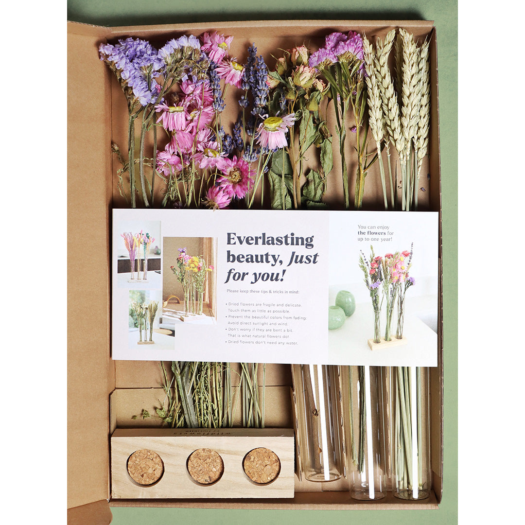 Box of dried flowers with a card inside, featuring text and images of floral arrangements.