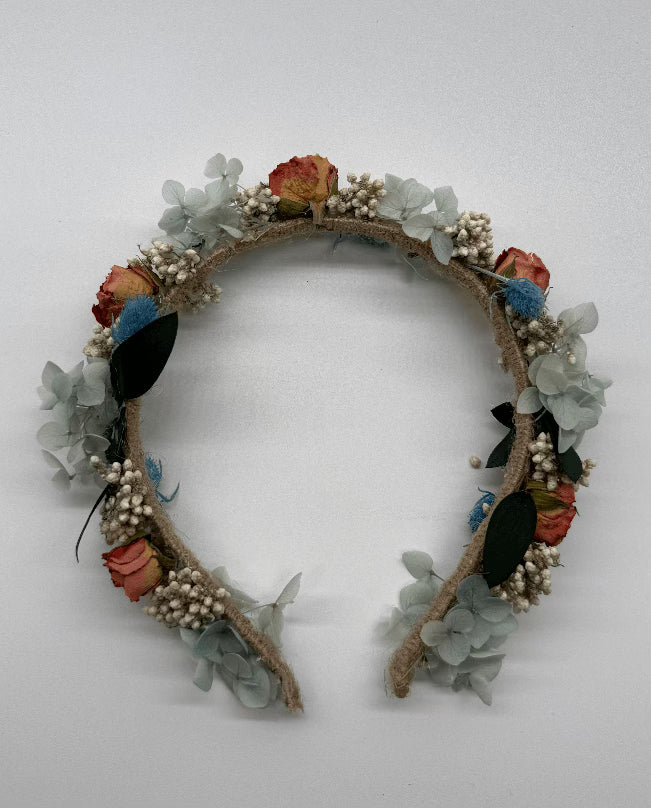 Floral headband with colorful flowers and green leaves on a white background