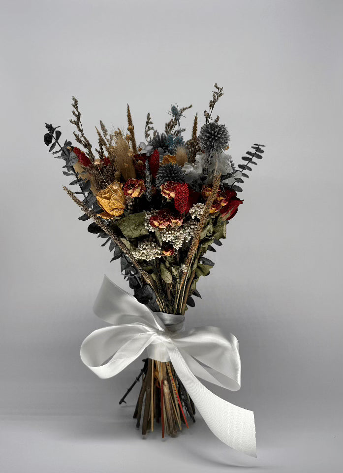 Bouquet of dried flowers with a white ribbon on a gray background