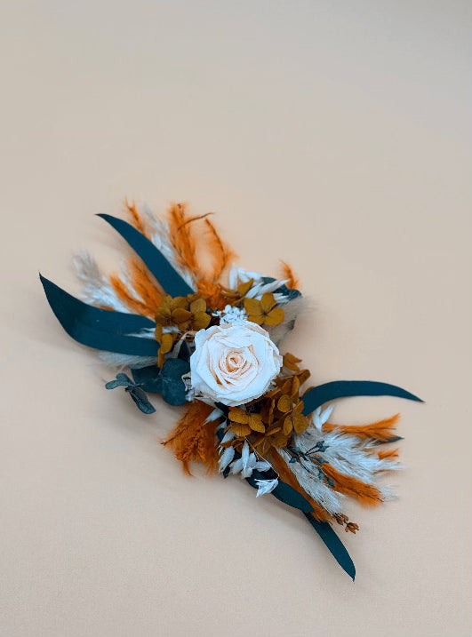 Floral arrangement with white rose, orange and green leaves on a beige background