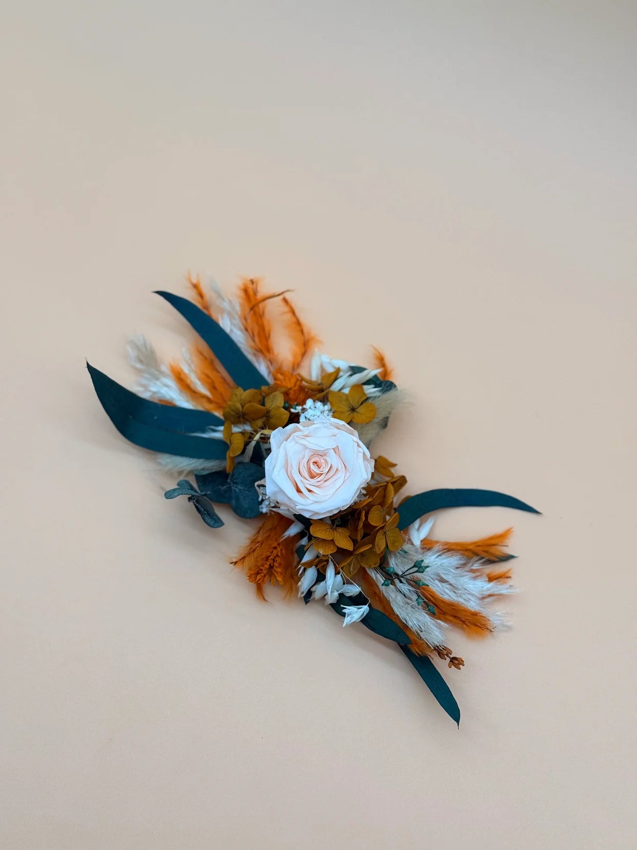 Floral and feather accessory on a beige background