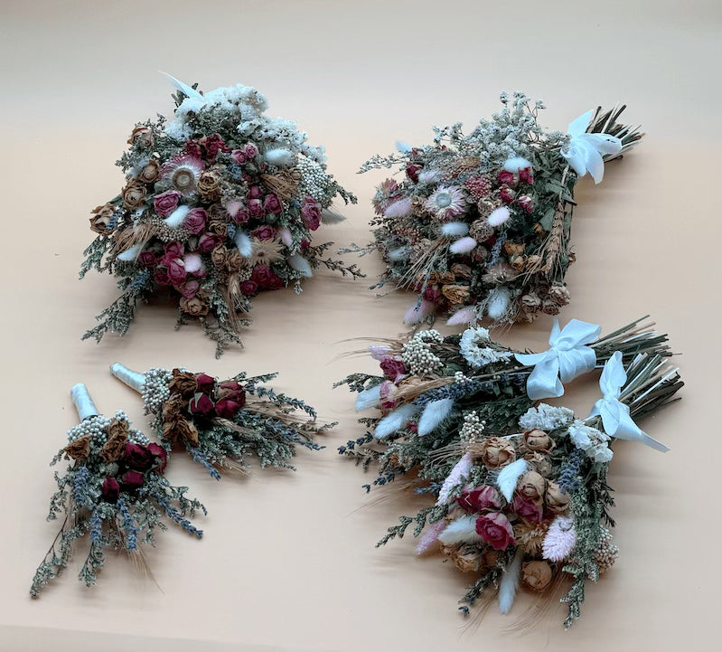 Four floral bouquets on a light wooden surface