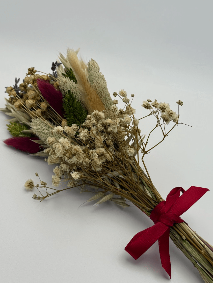 Bouquet of dried flowers with a red ribbon on a white background