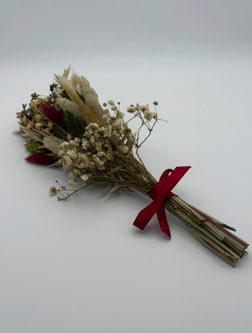 Bouquet of dried flowers with a red ribbon on a white background