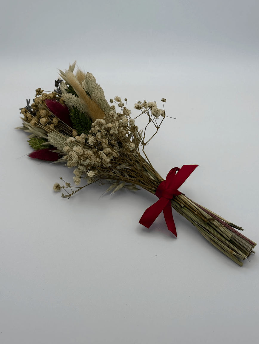 Bouquet of dried flowers with a red ribbon on a white background