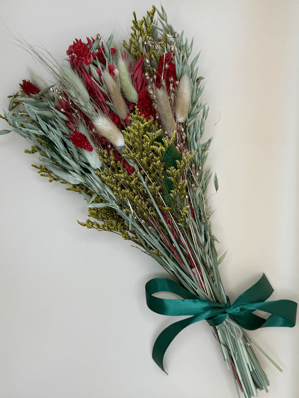 Bouquet of dried flowers with a green ribbon on a white background