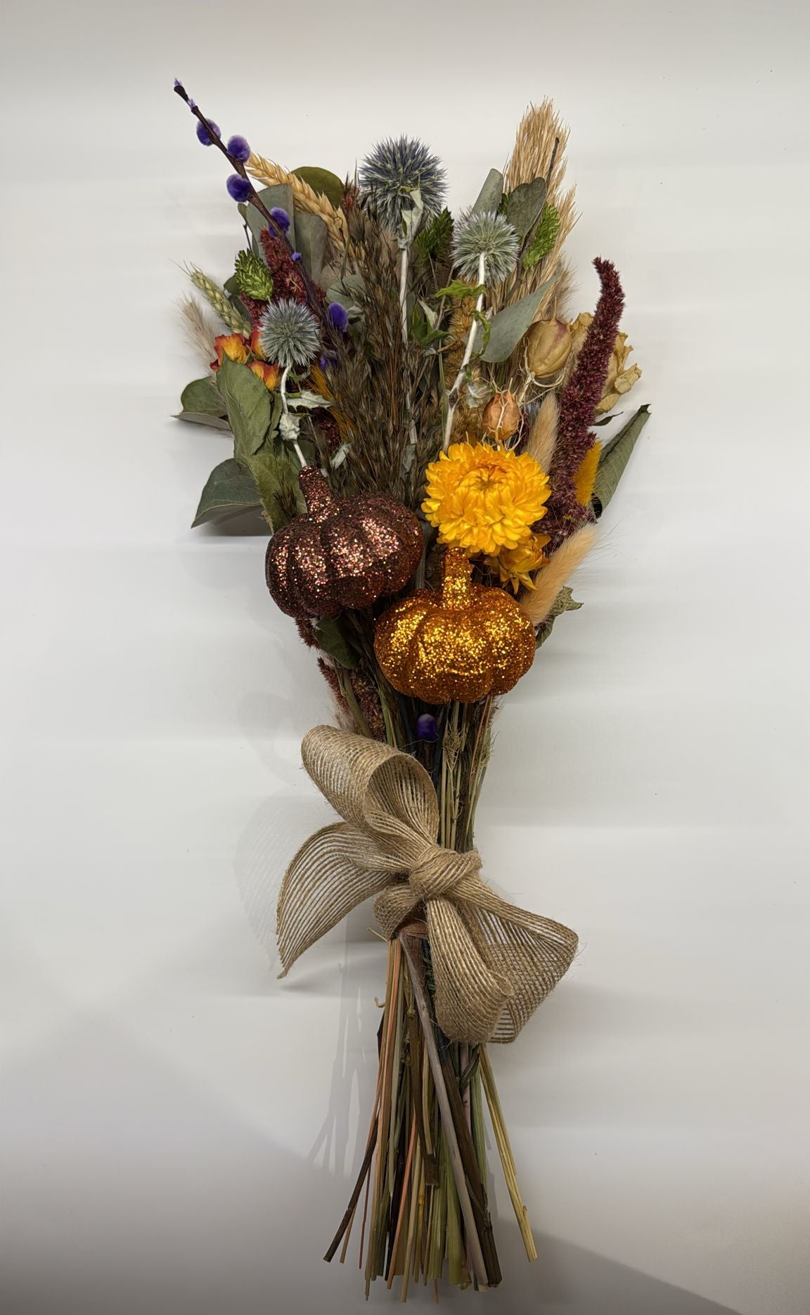 Bouquet of dried flowers with decorative ribbons on a white background
