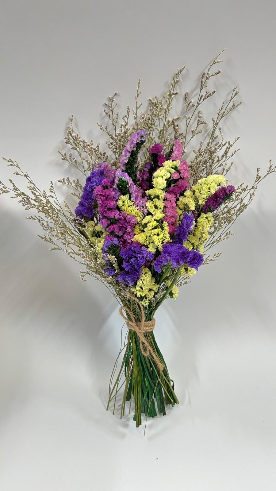 Bouquet of dried flowers with purple, yellow, and pink colors on a white background