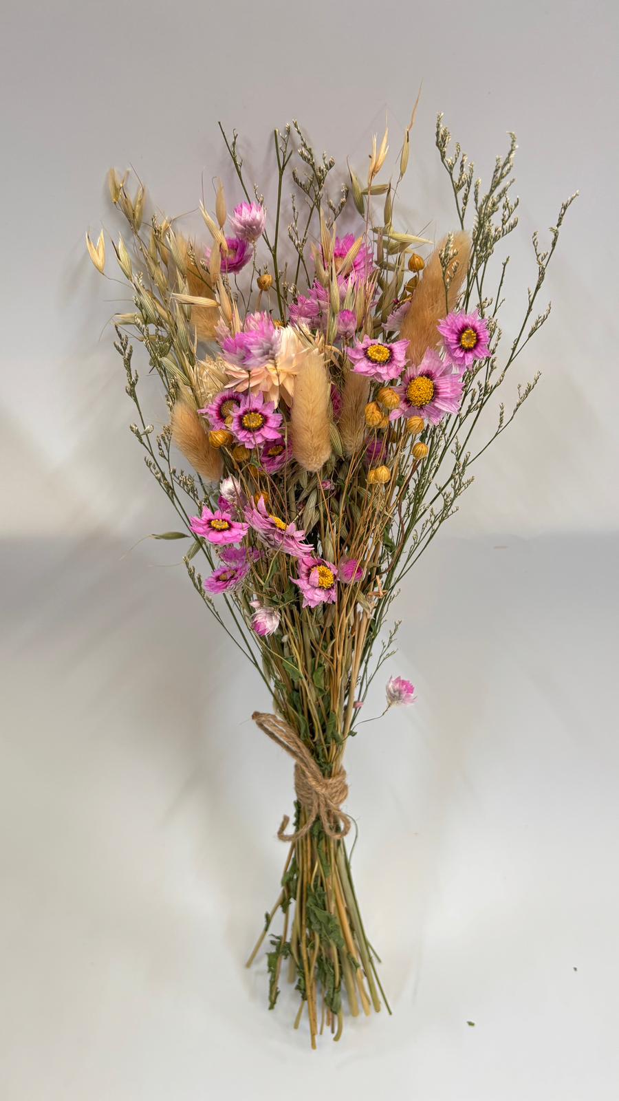 Bouquet of dried flowers tied with twine on a white background