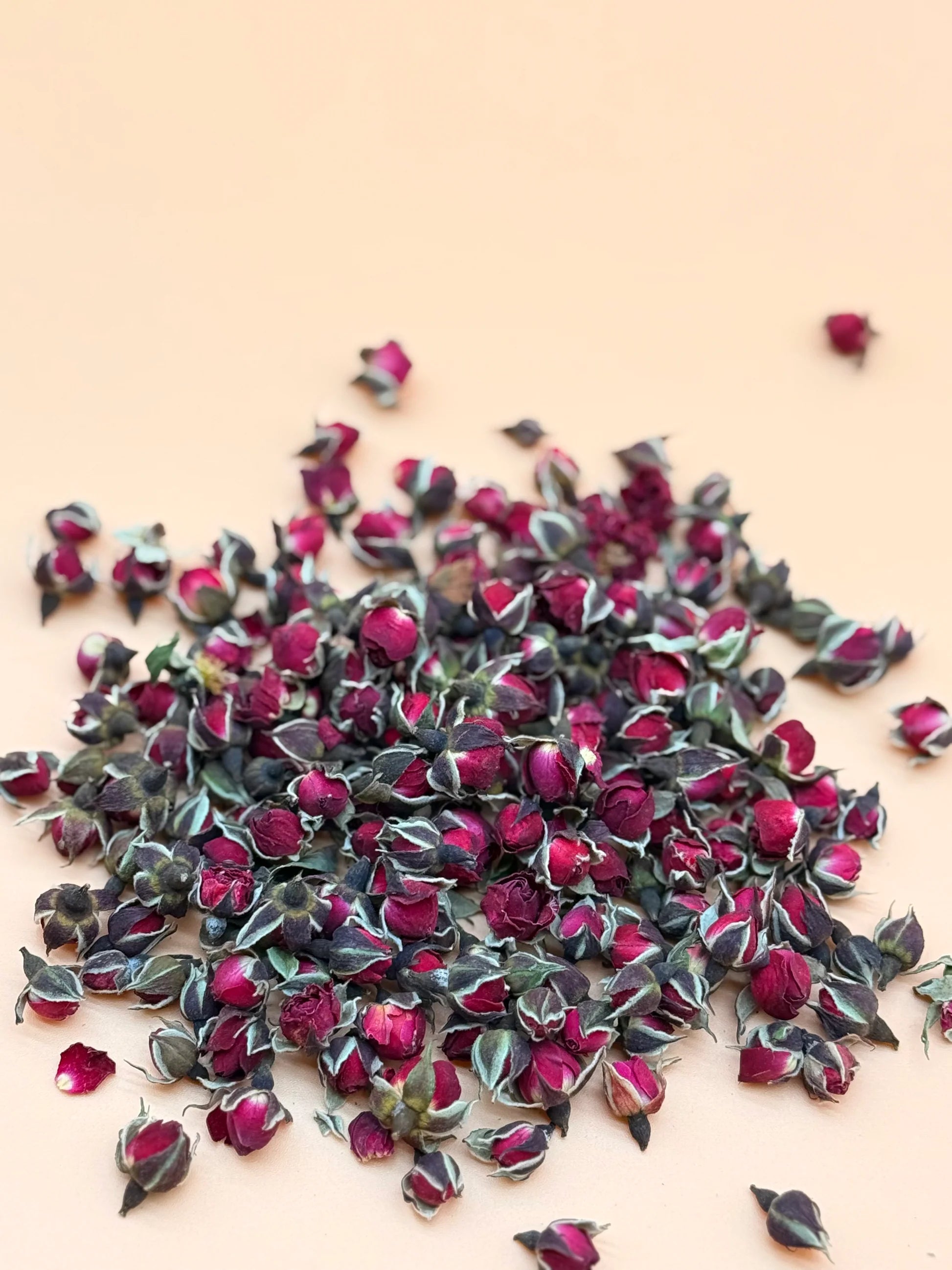 Pile of pink and green decorative flowers on a beige background