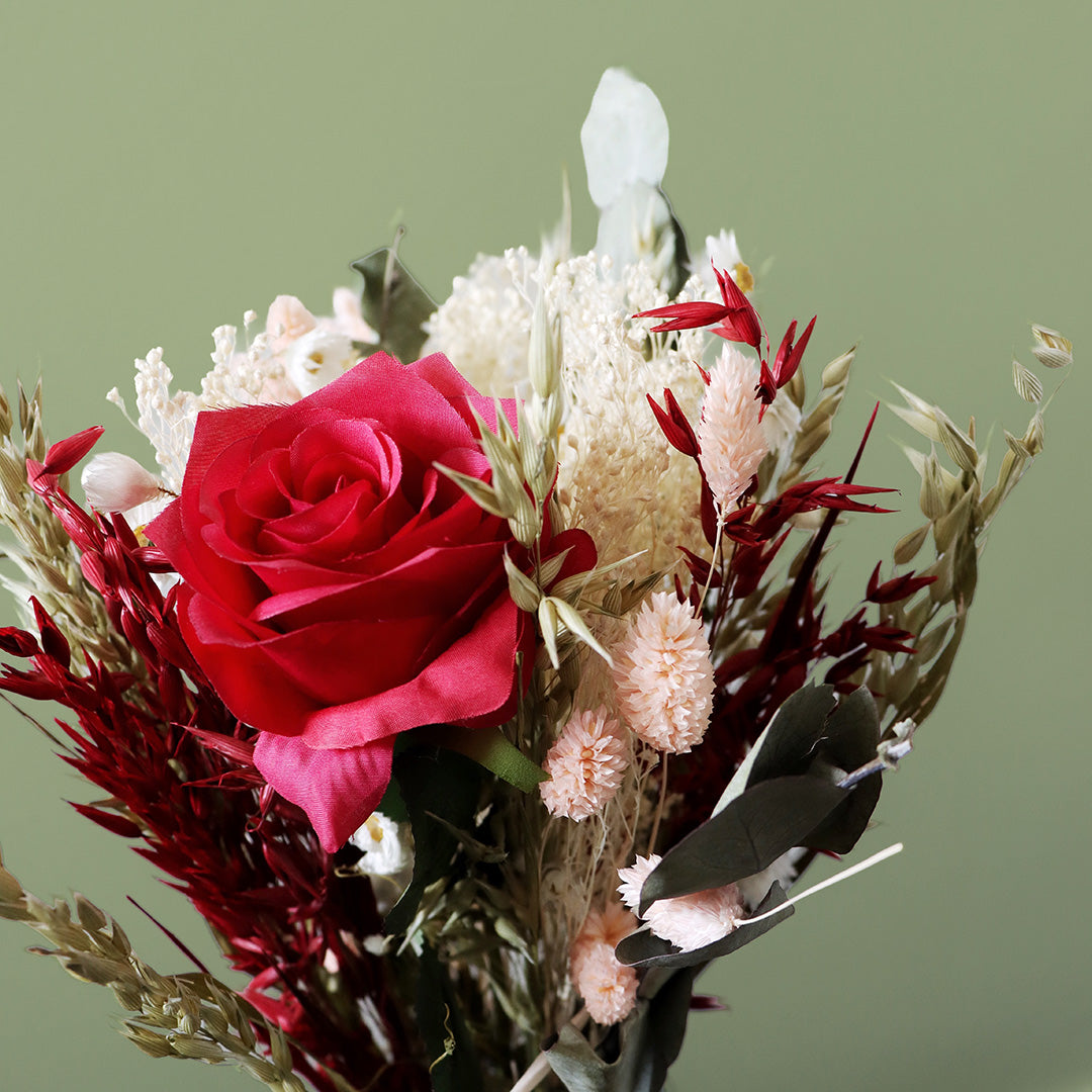 Bouquet of red roses and various other flowers on a green background