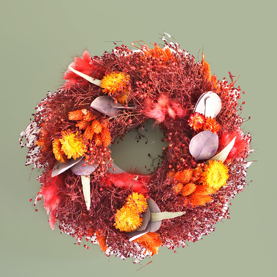 Decorative wreath with autumnal colors on a light green background