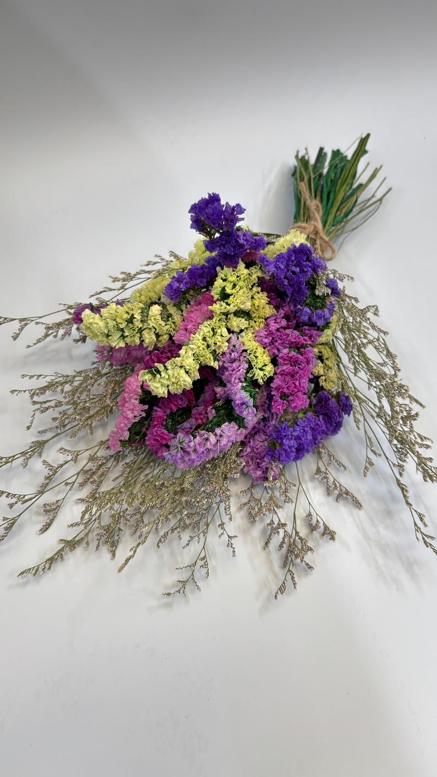Bouquet of dried flowers with purple, yellow, and pink colors on a white background