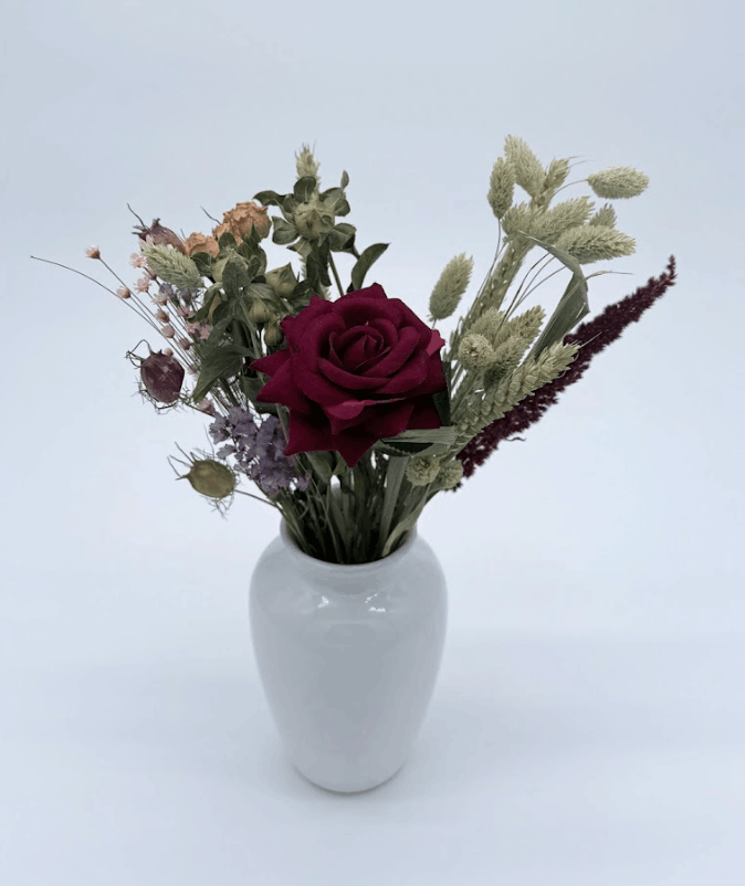 Bouquet of flowers in a white vase on a light gray background