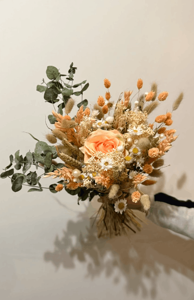 Bouquet of dried flowers and greenery on a neutral background