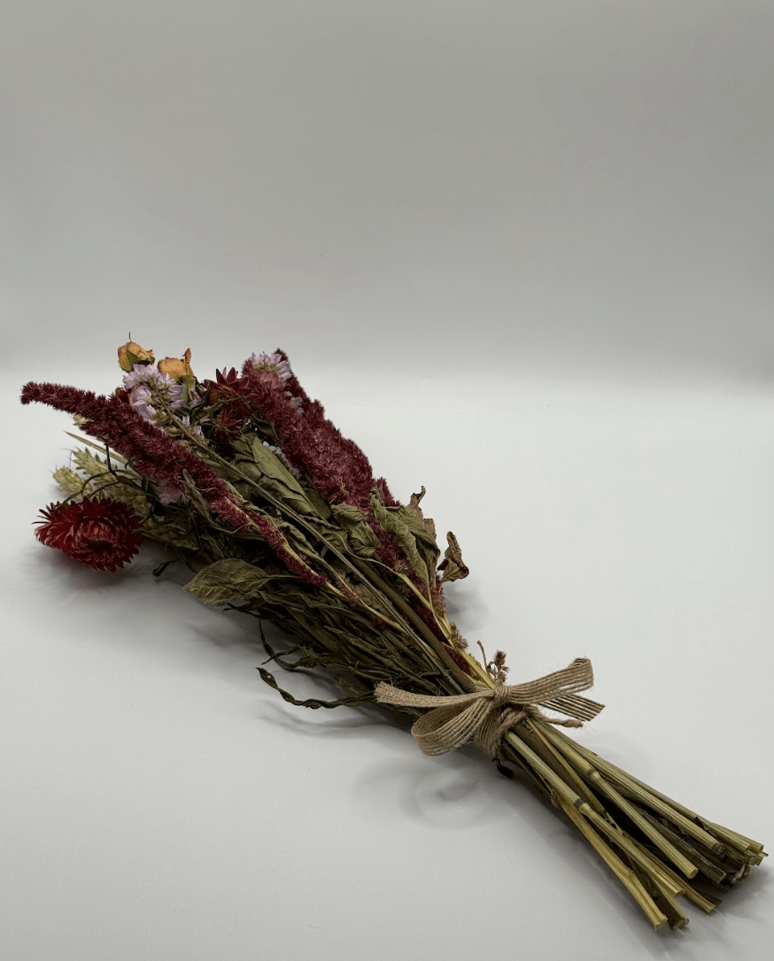 Bouquet of dried flowers tied with twine on a light gray background