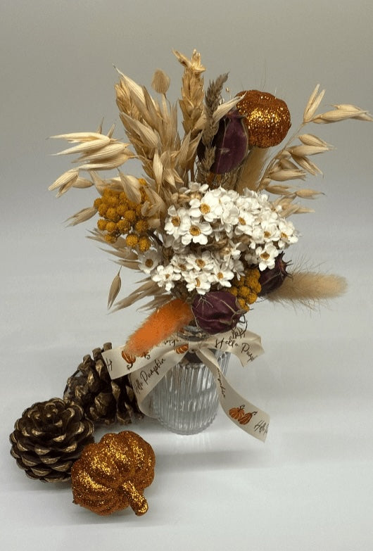 Bouquet of dried flowers with pinecones and acorns on a gray background