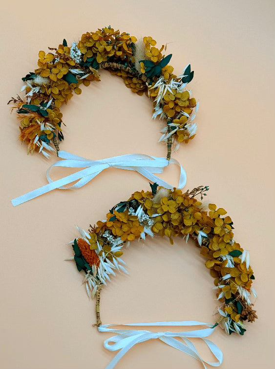 Two floral wreaths with blue ribbons on a beige background
