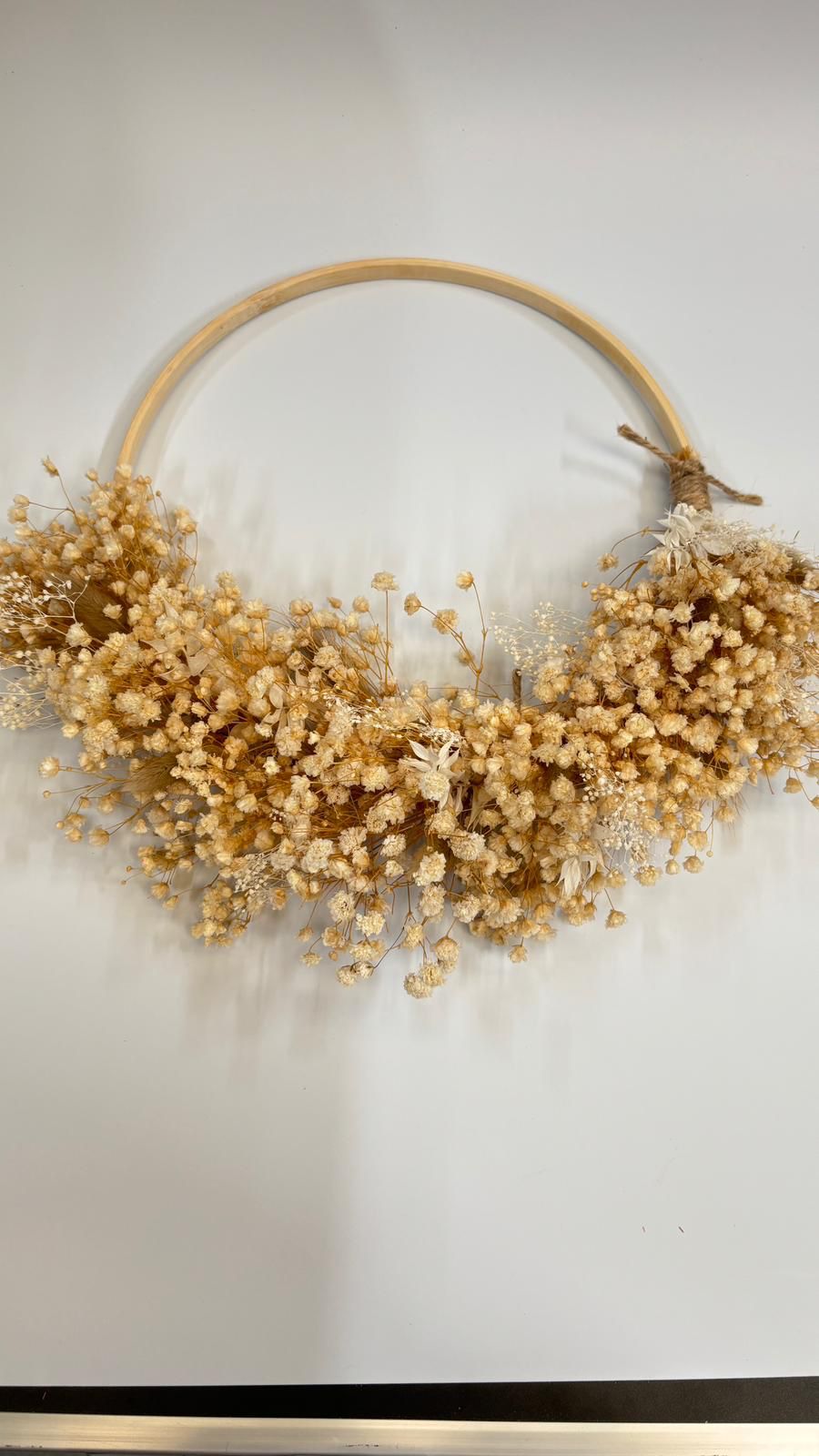 Decorative hoop with dried goldenrod flowers on a light background
